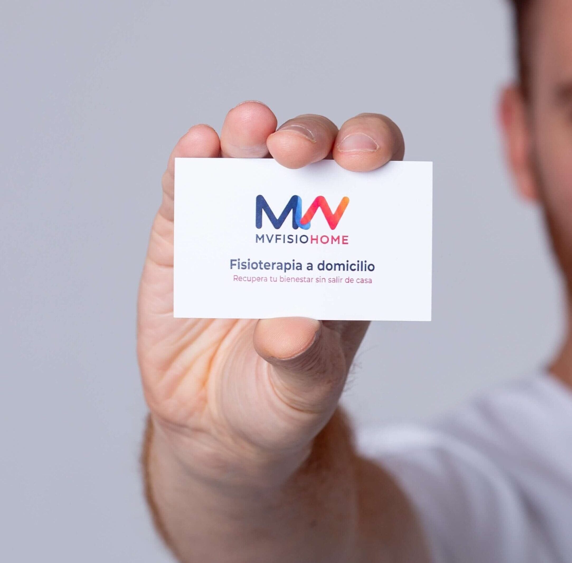Fisioterapeuta de MVFisioHome mostrando su tarjeta de visita para servicios de fisioterapia a domicilio en Sevilla.