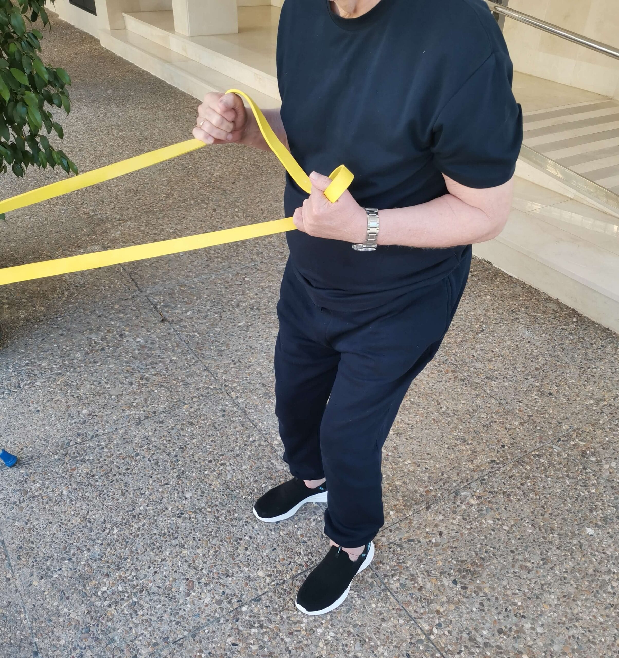 Ejercicio con banda elástica en fisioterapia a domicilio en Sevilla Paciente realizando ejercicio de fuerza con banda elástica durante sesión de fisioterapia a domicilio en Sevilla