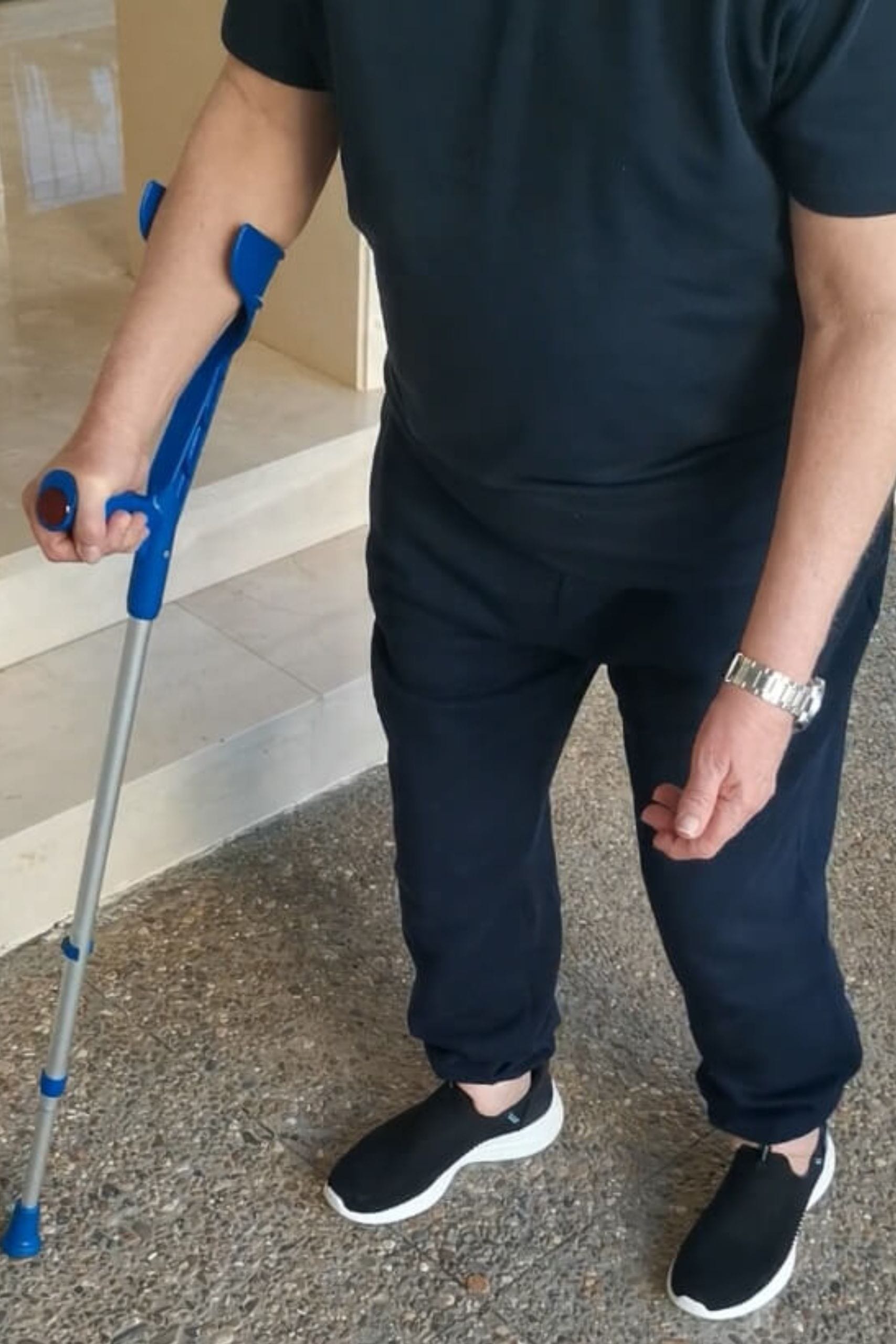 Senior adult with a quad cane providing support and stability indoors.