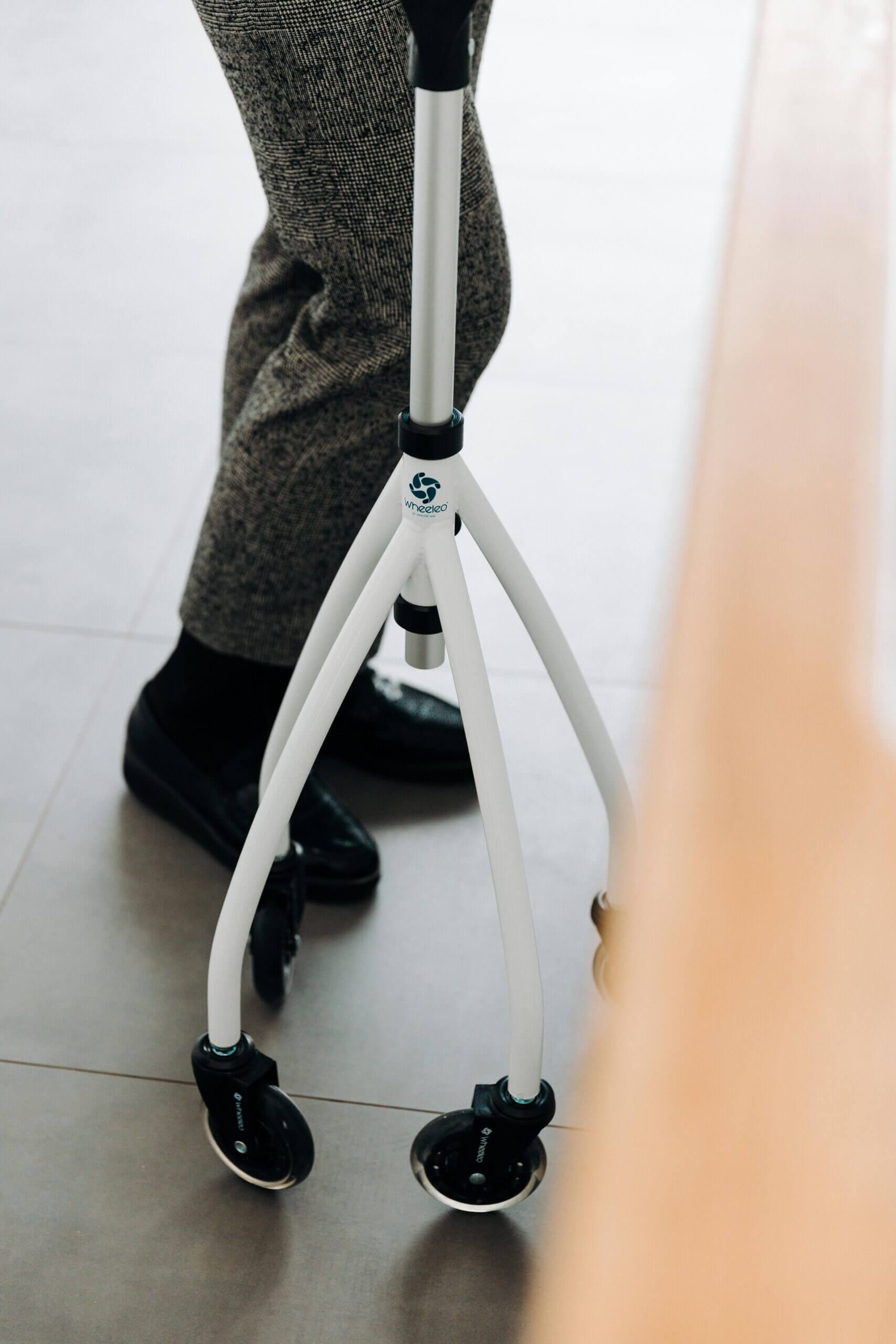 Senior adult with a quad cane providing support and stability indoors.